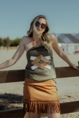 Minifalda marrón de gamuza con flecos en el ruedo y cierre trasero invisible.