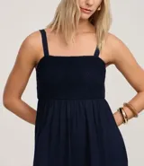 Vestido midi de corte evasé en color azul marino, confeccionado en una mezcla de algodón y lino. Presenta un escote cuadrado con tirantes anchos y un detalle de tejido con efecto crochet en la zona del busto.