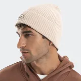 Gorro tipo beanie tejido en punto acanalado, con parche ovalado bordado en la parte frontal que incluye el logo de la marca.