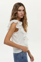 Blusa blanca vaporosa con volados en los hombros y cuello redondo.