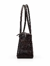 Cartera de cuero tipo baguette, con formato alargado, acabado de efecto vintage, dos asas largas para llevar al hombro y cierre superior.