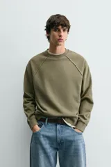 Sudadera relaxed fit color verde militar con efecto lavado, cuello redondo y manga larga. Confeccionada en tejido de algodón con interior afelpado y acabados en rib.