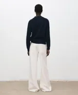 Sweater azul marino de punto, con cuello redondo y líneas blancas decorativas en las mangas raglán.