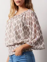Blusa de microtul estampado con hojas color marrón sobre fondo blanco, marca Harper. Tiene mangas 3/4 amplias y ruedo con punto smock. Incluye forro interno a tono.