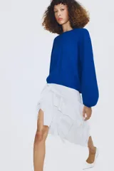 Jersey de punto color azul, con cuello redondo, mangas largas amplias y costuras marcadas en el frente.