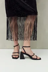 Falda larga negra de lentejuelas con terminación en flecos.