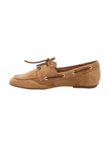 Mocasín de mujer estilo náutico marca RKF, modelo Roberta, confeccionado en 100% cuero gamuzado color marrón claro. Presenta cordones decorativos laterales con ojalillos metálicos dorados y cordón superior para atar.
