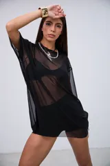 Remerón de microtul negro, semi transparente, de corte holgado y mangas cortas.