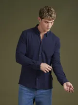 Camisa de hombre color azul marino, de piqué con cuello abotonado y manga larga.