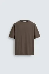 Camiseta de corte relajado confeccionada en algodón con textura irregular, cuello redondo y manga corta.