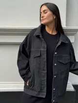 Campera clásica de jean negra con cuello camisero, bolsillos frontales y detalles de brillos plateados.