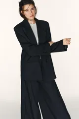 Blazer oversize de corte recto con estampado de raya diplomática, cuello con solapas de muesca, hombreras, manga larga y cierre frontal con botones. Cuenta con bolsillos de vivo en el delantero y forro interior.