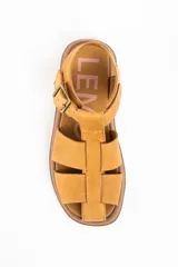 Sandalia tipo guillermina de cuero color camel, con diseño de tiras anchas entrelazadas, cierre con hebilla metálica lateral y suela de plataforma plana en tono marrón.