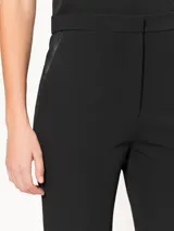 Pantalón negro de corte recto confeccionado en powermax. Presenta detalles de cuero ovino en los bolsillos delanteros.