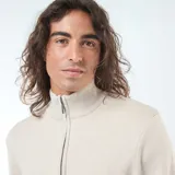 Sweater de punto color beige claro, con cuello alto y cierre frontal parcial de cremallera. Presenta puños y bajo acanalados.