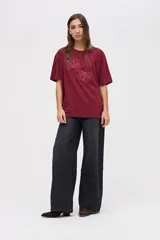 Remera de algodón lavado con textura suave, de calce clásico y manga corta. Presenta un bordado lineal de flores a tono en la parte frontal.