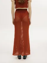 Falda maxi de tiro alto, confeccionada en tejido de punto calado de algodón color verde oscuro, con pretina elástica.