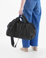 Bolso tipo tote color beige con diseño acolchado y doble asa de hombro.