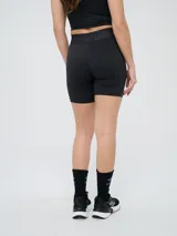 Biker deportiva Umbro para mujer, de color negro, confeccionada con tejido elástico y pretina cruzada con elástico personalizado de la marca.