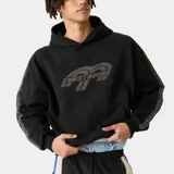 Hoodie oversize negro con capucha y bolsillo canguro frontal, con estampa gris de la marca EM ESTUDIOS en el pecho.