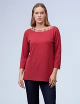 Blusa blanca de tejido elastizado marca Ruby Rd. Tiene escote redondo con aplique metálico y mangas 3/4.