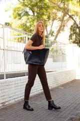 Botinetas de cuero negro con paneles laterales de gamuza al tono. Presentan una suela track robusta con taco cuadrado y cierre lateral para facilitar el calce.