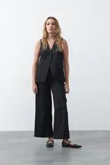 Pantalón wide leg color marrón chocolate, de tiro medio y corte relajado. Presenta detalle de hebillas laterales con ojales metálicos en la cintura y una caída fluida.