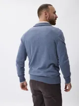 Sweater de tejido de punto en color azul, con cuello alto y cierre frontal parcial. Presenta mangas largas con puños acanalados y un pequeño detalle bordado en el pecho.
