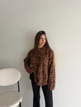 Buzo de peluche con estampado animal print de leopardo, cuello redondo y mangas largas.