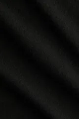 Buzo negro de punto fino suave con hombros descubiertos y escote enrollado. Modelo de manga larga con hombros caídos y remate acanalado en puños y bajo.