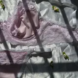Conjunto de lencería de dos piezas color rosado, compuesto por un soutiene con aro y detalles de encaje, y una bombacha a juego.
