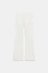 Jeans de denim azul oscuro con efecto desgastado y lavado, tiro bajo, corte bootcut y bajo flare. Presenta cinco bolsillos y cierre frontal con cremallera y botón.