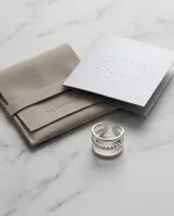 Set de tres anillos de acero quirúrgico en color plateado, con diseños minimalistas que incluyen dos bandas lisas y una con textura facetada o entrelazada.