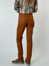 Pantalón negro de corte recto, estilo jean, con acabado engomado que simula cuero.