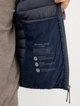 Chaleco acolchado de hombre confeccionado en nylon reciclado, con cierre frontal de cremallera, sisas elásticas y bolsillos laterales con cierre.