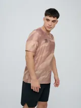 Remera deportiva Umbro modelo Niso, de manga corta y cuello redondo, con estampado abstracto en tonos negro y gris, y logo de la marca impreso en el pecho.