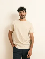 Remera básica de algodón color beige, de manga corta, con cuello redondo y un pequeño detalle bordado en el pecho.
