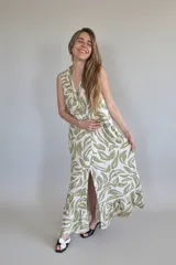 Vestido largo camisero sin mangas, con estampado de hojas en verde y blanco, cuello camisero y cierre frontal con botones.