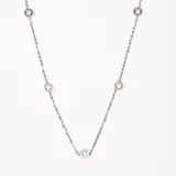 Collar plateado de cadena fina con cinco pequeños dijes circulares con incrustaciones de cristal.