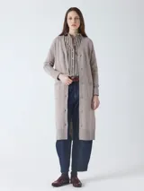 Cárdigan largo de tejido de punto, color beige topo, con mangas largas y botones frontales. Presenta un calce holgado y bolsillos delanteros.