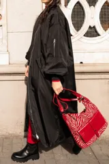 Campera bomber larga color negro, de nylon, con cierre frontal y bolsillos laterales.