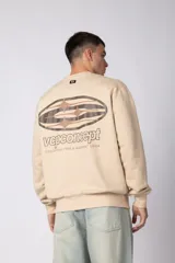 Buzo de cuello redondo en color arena, con diseño de calce regular y estampado gráfico minimalista en el pecho. Presenta puños y ruedo acanalados, con un pequeño detalle de etiqueta en el puño izquierdo.