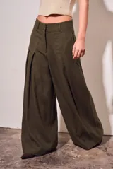 Pantalón wide leg de tiro alto color marrón oscuro, confeccionado en mezcla de viscosa y lino. Cuenta con bolsillos laterales y pinzas frontales que aportan amplitud y movimiento.