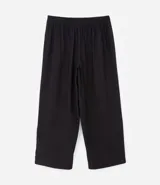 Pantalón negro de vestir, tiro alto, corte wide leg (pierna ancha), con bolsillos laterales y cierre frontal con cremallera y gancho.