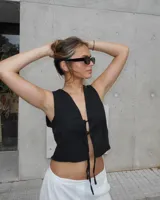 Chaleco negro con escote en V y lazo de ajuste en el frente.