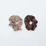 Pack de dos coleteros de tela satinada con estampado animal print de leopardo en tonos marrón y negro.