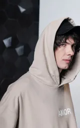 Hoodie oversize color gris topo, confeccionado en rústico de algodón, con capucha forrada, bolsillo canguro y costuras expuestas en mangas y ruedo. Presenta estampa gráfica en la espalda con la palabra AMOR y diversos motivos románticos.