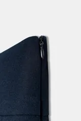 Falda pantalón de tiro bajo color azul marino, con detalle de falsos botones metálicos en el frente y cierre lateral con cremallera oculta.