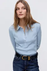 Remera polo de manga larga en punto de algodón, con cuello clásico, tapeta con botones y costuras moldeadoras en el frente.