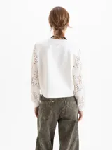 Buzo de calce regular con cuerpo de tela lisa y mangas largas de tejido calado con textura. Presenta escote redondo y puños ajustados.